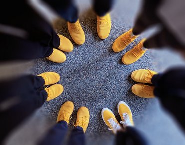 Top view of yellow shoes arranged in a circle.
